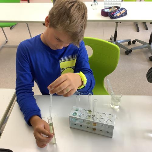 Kind füllt Flüssigkeiten in ein Reagenzglas