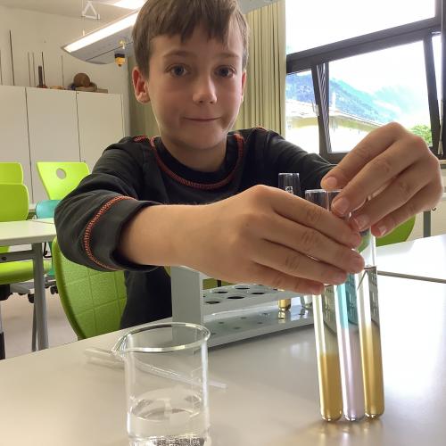 Kind mit drei Reagenzgläsern