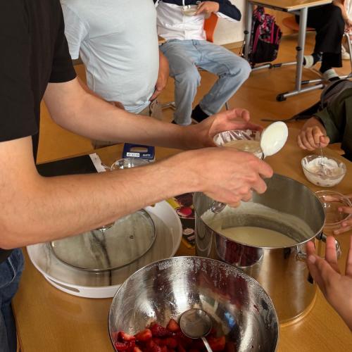 Joguhrt und Erdbeeren werden bei der Jause an die Klasse verteilt.