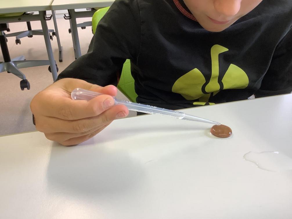 Kid tropft Wasser auf eine 5-Cent-Münze