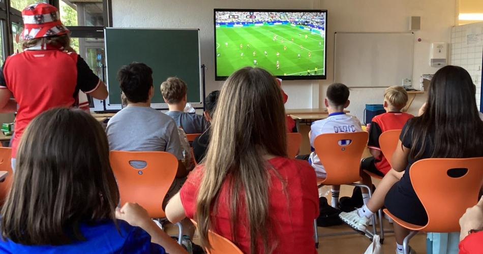 Kinder schauen das WM-Spiel Österreich gegen Argentinien in der Klasse.